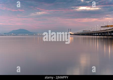 Sonnenaufgang unter der Penang Brücke. Penang-Brücken sind Überquerungen über die Penang-Straße in Malaysia. Stockfoto