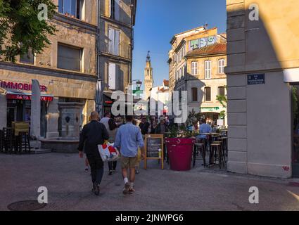 Typische Straßenszene. Glockenturm des Couvent des Augustins, des Augustinerklosters, im Hintergrund. Avignon, Vaucluse, Frankreich. Stockfoto