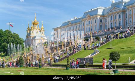 22. Juni 2022, Peterhof, Sankt Petersburg, Russland. Großer Palast, Brunnen und viele Touristen im unteren Park von Peterhof an einem hellen sonnigen Tag Stockfoto