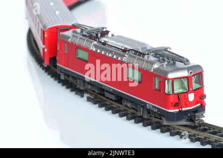 Maßstab Spielzeug Modell der roten Zug isoliert auf weiß reflektierenden Hintergrund Stockfoto