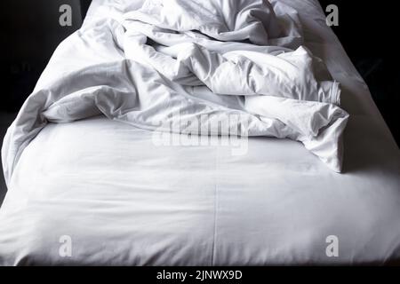 Weiße Decke im Bett nach dem Aufwachen am Morgen im Hotel Stockfoto