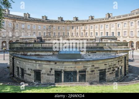 The Crescent in Buxton Derbyshire, ein denkmalgeschütztes georgianisches Gebäude der Klasse 1, das an den Hängen liegt (im Vordergrund ist der Pumproom). Stockfoto