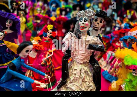 Mexikanische Calaca-Figuren, die während der Feierlichkeiten zum Tag der Toten verwendet werden, werden auf dem Markt in Mexiko-Stadt, Mexiko, verkauft. Stockfoto