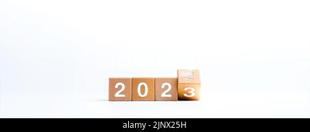 2023 Happy New Year Concept Banner. Den Kalender mit 2022 bis 2023 Jahreszahlen auf hölzernen Würfelblöcken spiegeln, die auf weißem Hintergrund für das neue Jahr ch isoliert sind Stockfoto