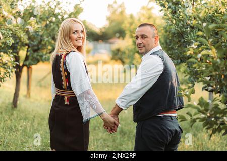 Ehemann und Ehefrau in serbischer traditioneller Kleidung, Hände haltend Stockfoto