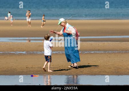 Southport, Merseyside, 14. August 2022. Die Menschen begeben sich auf den goldenen Sand am Southport Beach, um sich abzukühlen und sich unter den heißen Hitzebedingungen in Großbritannien zu amüsieren. Quelle: Cernan Elias/Alamy Live News Stockfoto