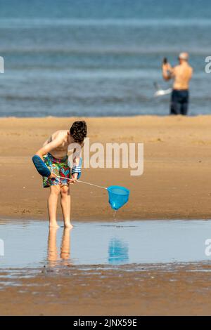 Southport, Merseyside, 14. August 2022. Die Menschen begeben sich auf den goldenen Sand am Southport Beach, um sich abzukühlen und sich unter den heißen Hitzebedingungen in Großbritannien zu amüsieren. Quelle: Cernan Elias/Alamy Live News Stockfoto