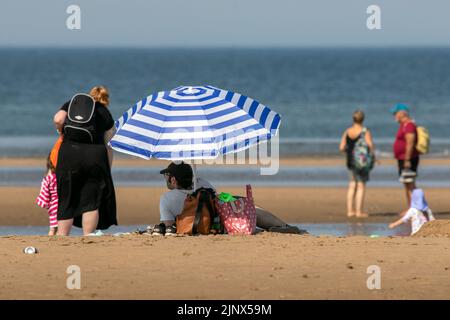 Southport, Merseyside, 14. August 2022. Die Menschen begeben sich auf den goldenen Sand am Southport Beach, um sich abzukühlen und sich unter den heißen Hitzebedingungen in Großbritannien zu amüsieren. Quelle: Cernan Elias/Alamy Live News Stockfoto