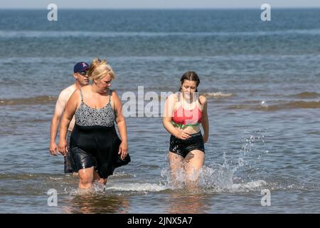 Southport, Merseyside, 14. August 2022. Die Menschen begeben sich auf den goldenen Sand am Southport Beach, um sich abzukühlen und sich unter den heißen Hitzebedingungen in Großbritannien zu amüsieren. Quelle: Cernan Elias/Alamy Live News Stockfoto