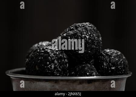 Schwarzer Sesamladdu (in tamilischer Sprache auch als ellu urundai bekannt) wird aus Sesamsamen und Zacken hergestellt Stockfoto
