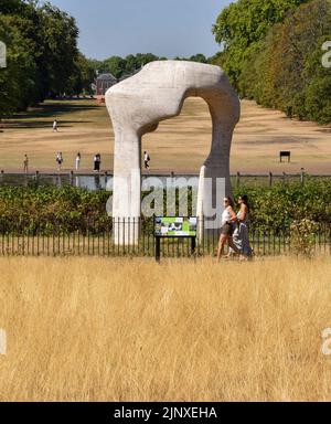 London, Großbritannien. 14.. August 2022. Trockenes Gras umgibt die Skulptur „The Arch 1979–1980“ von Henry Moore in den Kensington Gardens, da in Teilen Englands offiziell eine Dürre erklärt wird. Kredit: Vuk Valcic/Alamy Live Nachrichten Stockfoto