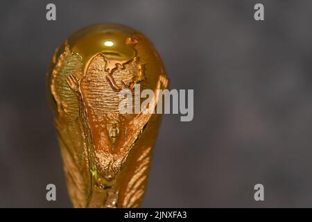 DOHA, KATAR - 14. AUGUST 2022: FIFA WM-Trophäe vor grauem Hintergrund Stockfoto