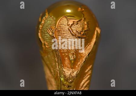 DOHA, KATAR - 14. AUGUST 2022: FIFA WM-Trophäe vor grauem Hintergrund Stockfoto