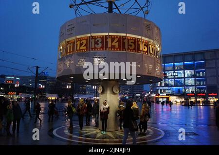 Berlin, Deutschland: Menschen versammelten sich um die Urania-Weltuhr auf dem Alexanderplatz, bei Nacht Stockfoto