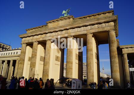 Berlin, Deutschland: Menschen versammelten sich unter dem Brandenburger Tor, von unter den Linden aus gesehen Stockfoto