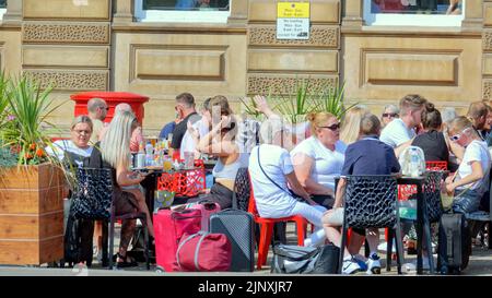 Glasgow, Schottland, Großbritannien. 14. August 2022. Wetter in Großbritannien: Bei sonnigem Wetter überfluteten Einheimische und Touristen die Straßen. Der George Square mit seinen Widerlöffeln im Freien und offenen Plätzen macht ihn zum Hot Spot für die Mittagszeit. Quelle: gerard Ferry/Alamy Live News Stockfoto