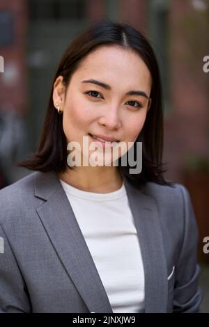 Junge selbstbewusste elegante asiatische Geschäftsfrau, vertikales Headshot Porträt. Stockfoto