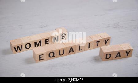 Holzblöcke, die das Wort Frauen Gleichheitstag Stockfoto