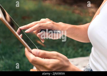 Nahaufnahme einer Frau, die in einem Park schreibt und ein Notizbuch benutzt Stockfoto