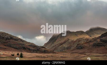 Epische Landschaft mit Sonnenaufgangslicht über Blea Tarn im Lake District mit atemberaubendem Licht auf fernen Bergen Stockfoto