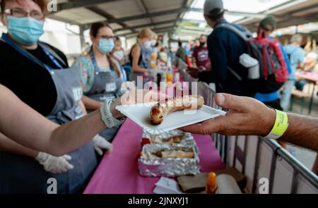 Hamburg, Deutschland. 14. August 2022. Freiwillige geben Würstchen, Getränke und Zubehör beim Barbecue Summer Festival für Bedürftige und Obdachlose aus. Quelle: Markus Scholz/dpa/Alamy Live News Stockfoto