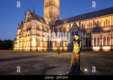 Walking Madonna Statue vor der Salisbury Cathedral an einem Sommerabend, Wiltshire, England. Stockfoto