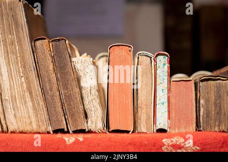 Alte Bücher, die auf einem Markttisch ruhen und auf einem Antiquitätenmarkt in Dordrecht in den Niederlanden verkauft werden. Hollands Second-Hand-Literatur-Veranstaltung Stockfoto