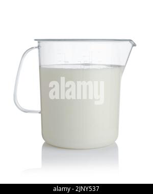 Frische Milch in einem großen Messbecher aus Kunststoff, isoliert auf Weiß. Stockfoto