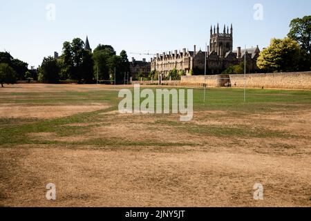 Oxford, Großbritannien. 12.. August 2022. Das Merton College wird über ein ausgetrocknenes Merton-Feld betrachtet. Heiße und trockene Bedingungen setzen sich im Süden Englands fort Stockfoto