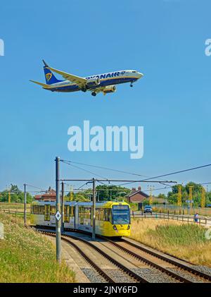 Die Straßenbahn Manchester Metrolink nähert sich der Haltestelle Manchester Airport, Manchester, England. Stockfoto