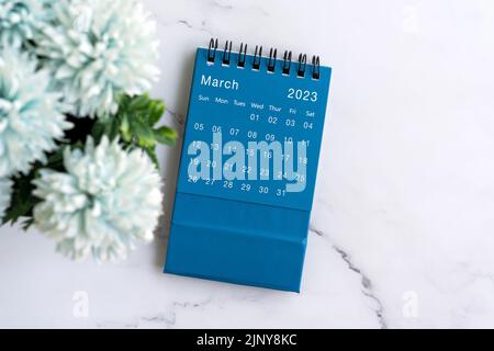 März 2023 flacher Lay-Kalender mit Blume Stockfoto