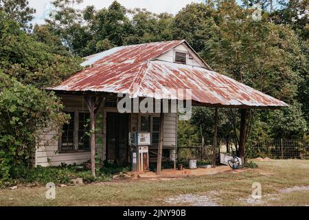 Eine alte geschlossen und verlassene Tankstelle, oder Service Station, entlang einer Landstraße in ländlichen Alabama, USA. Stockfoto