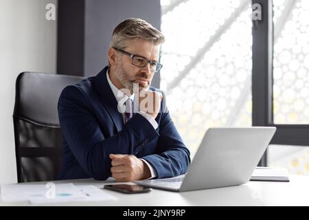 Beschäftigt Reifen Unternehmer In Brillen Arbeiten Mit Laptop Im Büro Stockfoto