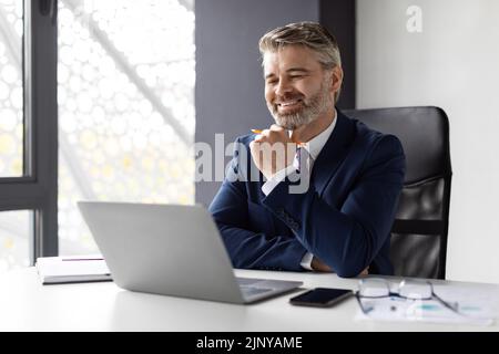 Lächelnd Reife Geschäftsmann Im Anzug Arbeiten Mit Laptop Im Büro Stockfoto