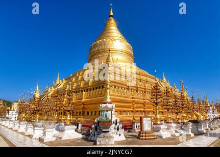 Die Shwezigon-Pagode in Bagan, Myanmar. Besteht aus einer kreisförmigen vergoldeten Stupa mit Blattgold, die von kleineren Tempeln und Schreinen umgeben ist Stockfoto