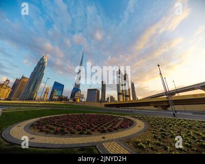 Weite Aufnahme des Stadtzentrums von Dubai bei Sonnenuntergang mit dem höchsten Gebäude der Welt, dem Burj Khalifa. Nach einem seltenen Regenguss ist der Himmel voller Wolken Stockfoto