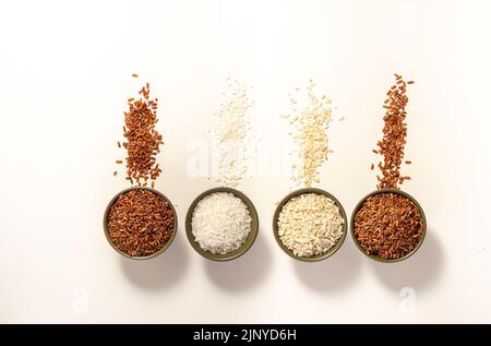Rohes Reissortiment in Schüssel auf weißem Hintergrund. Horizontal. Für Text platzieren. Draufsicht. Stockfoto