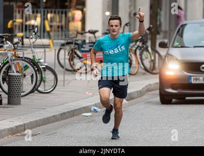 Hamburg, Deutschland. 14. August 2022. Der 16-jährige Student Denis Holub fährt nach seinem 1100 Kilometer langen Charity-Lauf von Freiburg nach Hamburg ins Ziel in der HafenCity. Mit seinem Lauf unterstützt der Gymnasiast die Arbeit von Mary's Meals, einer internationalen Kinderhilfsorganisation, die in Schottland gegründet wurde. Die Organisation unterstützt Kinder in Afrika, Asien, Osteuropa und Lateinamerika. (To dpa 'Student runs more than 1100 kilometers for a good cause') Quelle: Markus Scholz/dpa/Alamy Live News Stockfoto