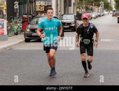 Hamburg, Deutschland. 14. August 2022. Nach seinem 1100 Kilometer langen Spendenlauf von Freiburg nach Hamburg läuft der 16-jährige Student Denis Holub (l.) mit seinem Laufgefährten Manfred Sandmann ein zweites Mal ins Ziel. Die er am Ende zurückließ. Mit seinem Lauf unterstützt der Gymnasiast die Arbeit von Mary's Meals, einer in Schottland gegründeten internationalen Kinderhilfsorganisation. Die Organisation unterstützt Kinder in Afrika, Asien, Osteuropa und Lateinamerika. (To dpa 'Student runs more than 1100 kilometers for a good cause') Quelle: Markus Scholz/dpa/Alamy Live News Stockfoto