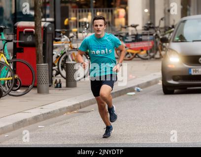 Hamburg, Deutschland. 14. August 2022. Der 16-jährige Student Denis Holub fährt nach seinem 1100 Kilometer langen Charity-Lauf von Freiburg nach Hamburg ins Ziel in der HafenCity. Mit seinem Lauf unterstützt der Gymnasiast die Arbeit von Mary's Meals, einer internationalen Kinderhilfsorganisation, die in Schottland gegründet wurde. Die Organisation unterstützt Kinder in Afrika, Asien, Osteuropa und Lateinamerika. (To dpa 'Student runs more than 1100 kilometers for a good cause') Quelle: Markus Scholz/dpa/Alamy Live News Stockfoto