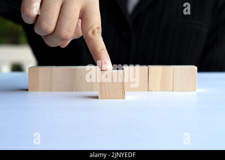 Hand, die einen Holzblock herausdrückt, leere Schablone Stockfoto