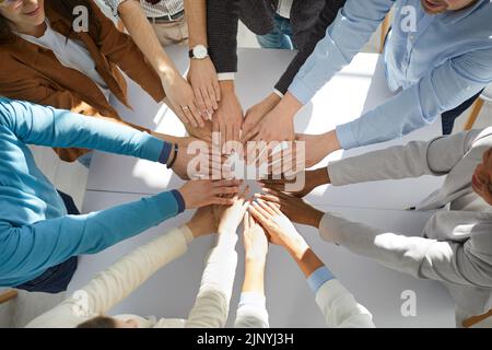 Von oben aus hat man einen Blick auf die Angestellten der Geschäftsleitung, die die Handflächen zusammenstellten Stockfoto