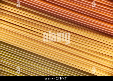 Abstrakt italienische Lebensmittel Hintergrund, rohe bunte Gemüse Spaghetti füllen den Rahmen in einem strukturierten Design aus roten, gelben und grünen diagonalen Pasta lin Stockfoto