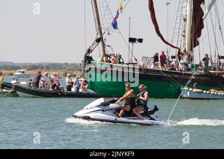 West Mersea Regatta auf Mersea Island in Essex. Die Regatta wird seit 1838 fast ununterbrochen durchgeführt und wird von Freiwilligen organisiert. Paar auf Jetski Stockfoto