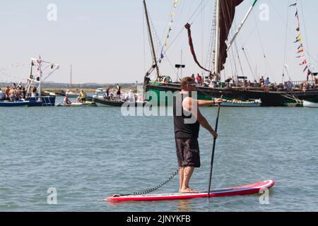 West Mersea Regatta auf Mersea Island in Essex. Die Regatta wird seit 1838 fast ununterbrochen durchgeführt und wird von Freiwilligen organisiert. Paddle-Boarder. Stockfoto