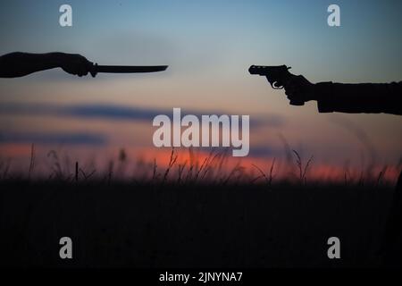 Katana gegen Revolver kämpfen im Feld. Militärischer Konflikt in Asien. Schlacht der großen Länder. USA, Taiwan gegen China im Konzept des politischen Weltkriegs Stockfoto