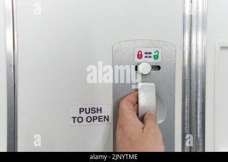Türverriegelungstaste für Toilette im Flugzeug Stockfoto