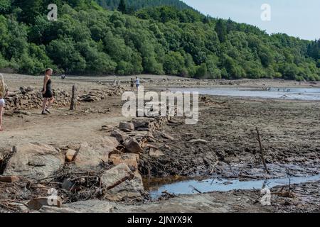 Nach einem langen, heißen Sommer 2022 beginnen nun die zurückgehenden Gewässer am Lake Vyrnwy-Staudamm alte Straßen und Gebäude im versunkenen Dorf zu enthüllen. Stockfoto