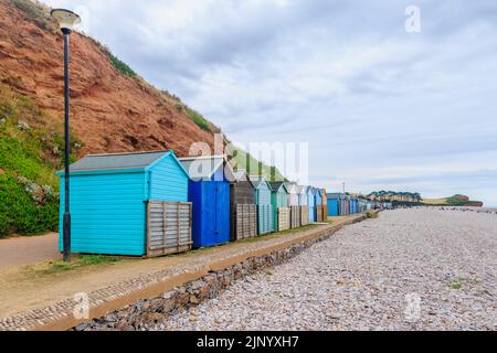 Geschlossene Holzstrandhütten an der Strandpromenade von Budleigh Salterton, einer kleinen, unberührten Küstenstadt in East Devon an der Jurassic Coast Stockfoto