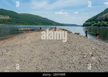 Nach einem langen, heißen Sommer 2022 beginnen nun die zurückgehenden Gewässer am Lake Vyrnwy-Staudamm alte Straßen und Gebäude im versunkenen Dorf zu enthüllen. Stockfoto